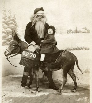 old time saint nick image with a child and a donkey