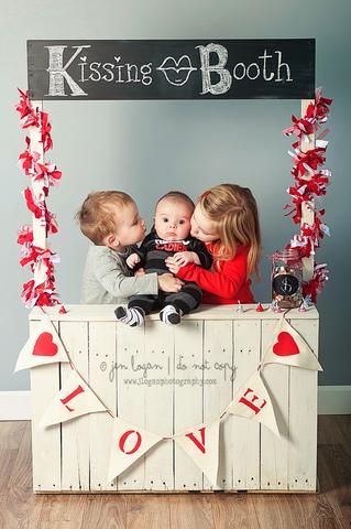 Two older siblings kissing baby brother on both of his cheeks