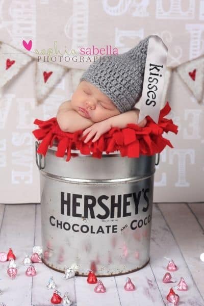 Baby sleeping in Hershey's tin with a gray knitted hat - Baby's First Valentine's Day Photo shoot