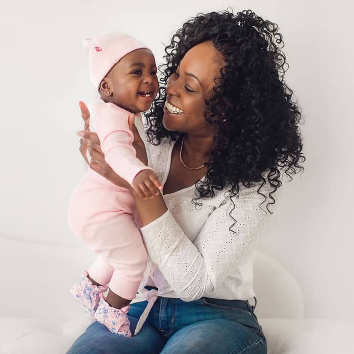 mom holding baby in pink outfit from zutano