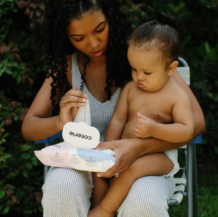 baby sitting on mom's lap with coterie wipes