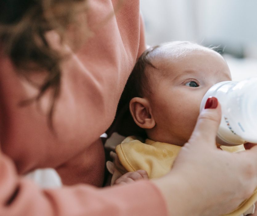 mom bottle feeding her infant baby formula