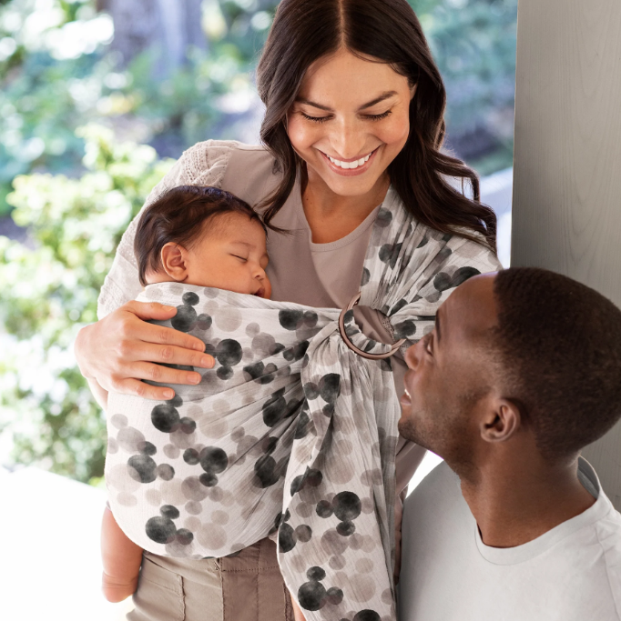 parent with baby in a mickey mouse baby wrap carrier