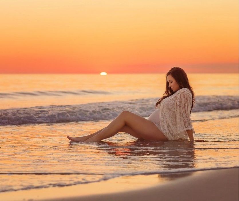 pregnant woman on the beach at sunset