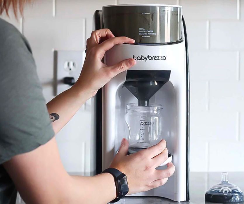 woman dispensing formula with a baby brezza