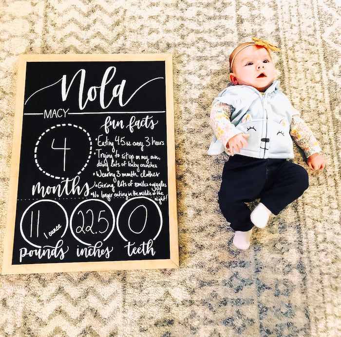 baby next to milestone chalkboard