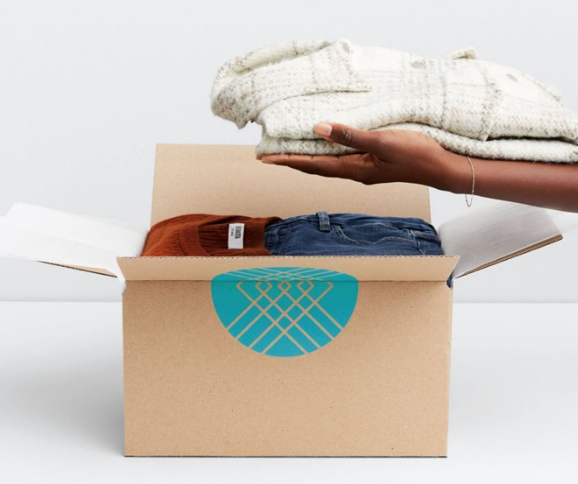 woman lifting maternity sweater out of Stitch Fix box