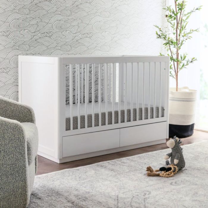 white crib with storage drawers in bedroom