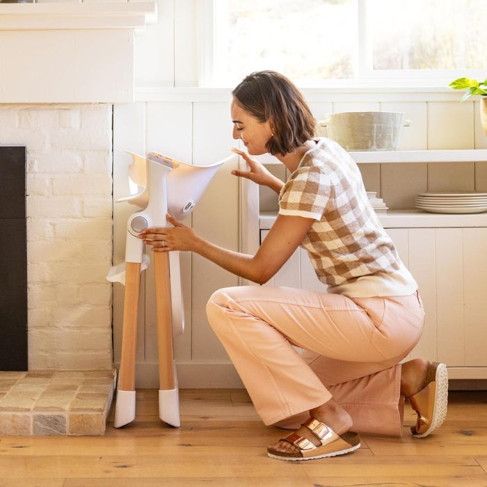 mom putting a Foldable High Chair in a small corner