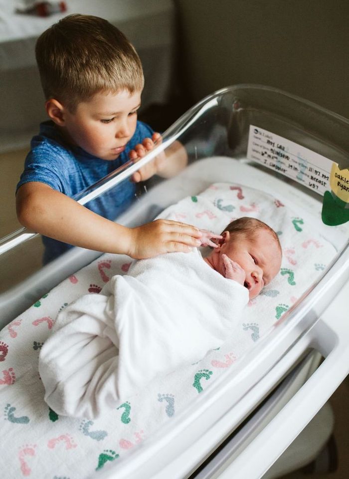 Big Brother at hospital looking at newborn baby sibling