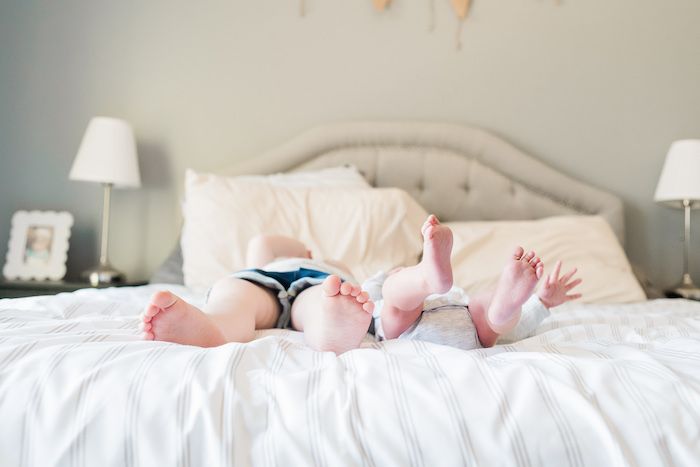 Older toddler sibling and newborn baby feet and toes