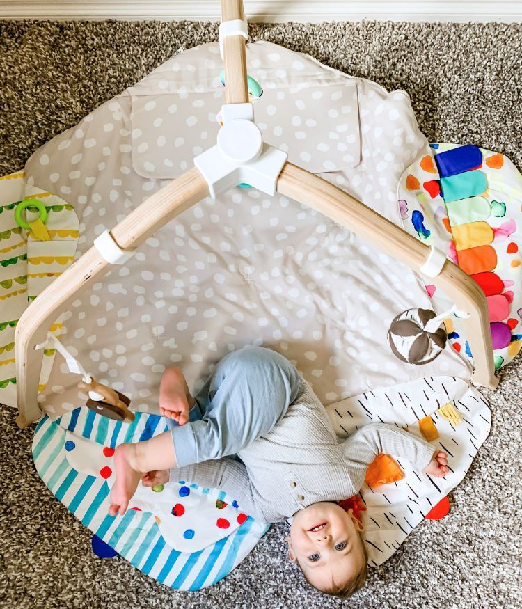 Birdseye view of baby laying on the floor looking up at the Lovevery play gym