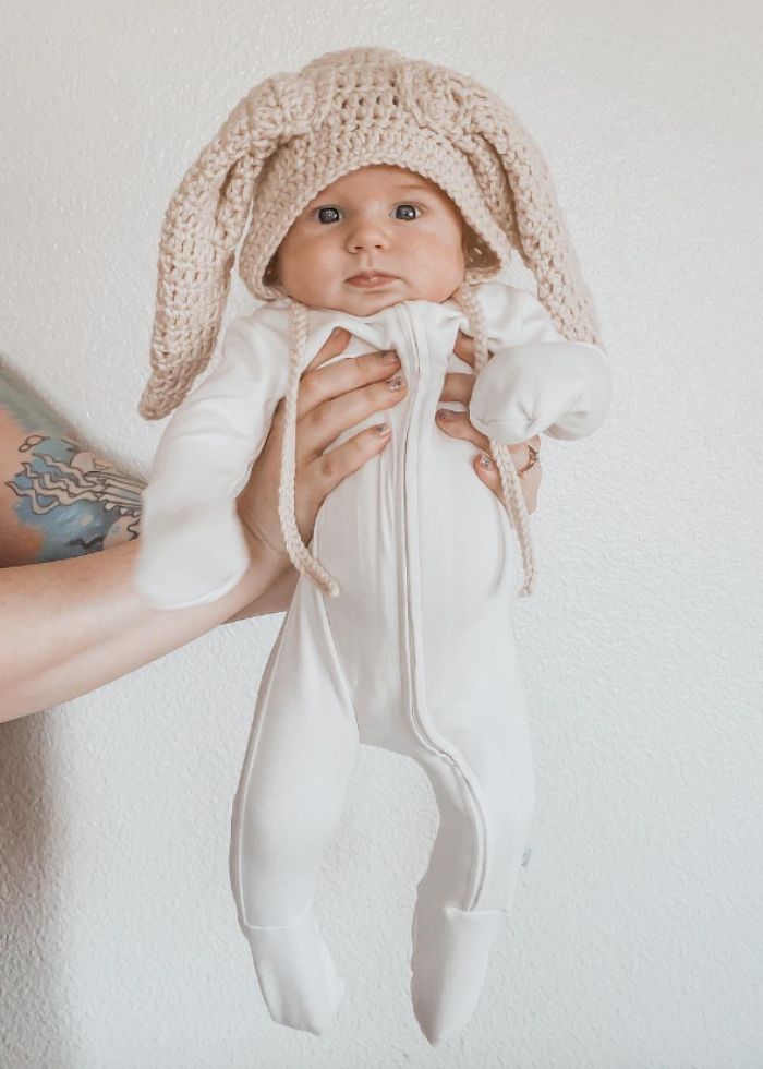 mom holding newborn baby wearing knitted bunny hat